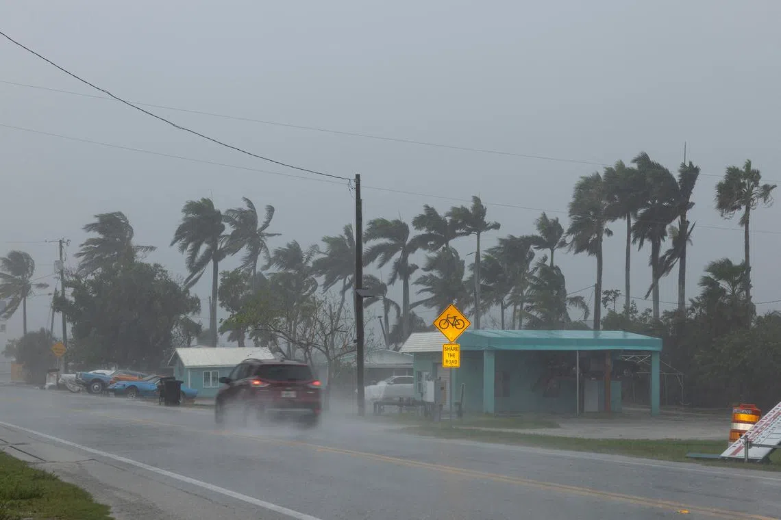 A motorist drives amid heavy rain and wind gusts before the arrival of Hurricane Milton in Matlacha, Florida, U.S. October 9, 2024. REUTERS/Ricardo Arduengo