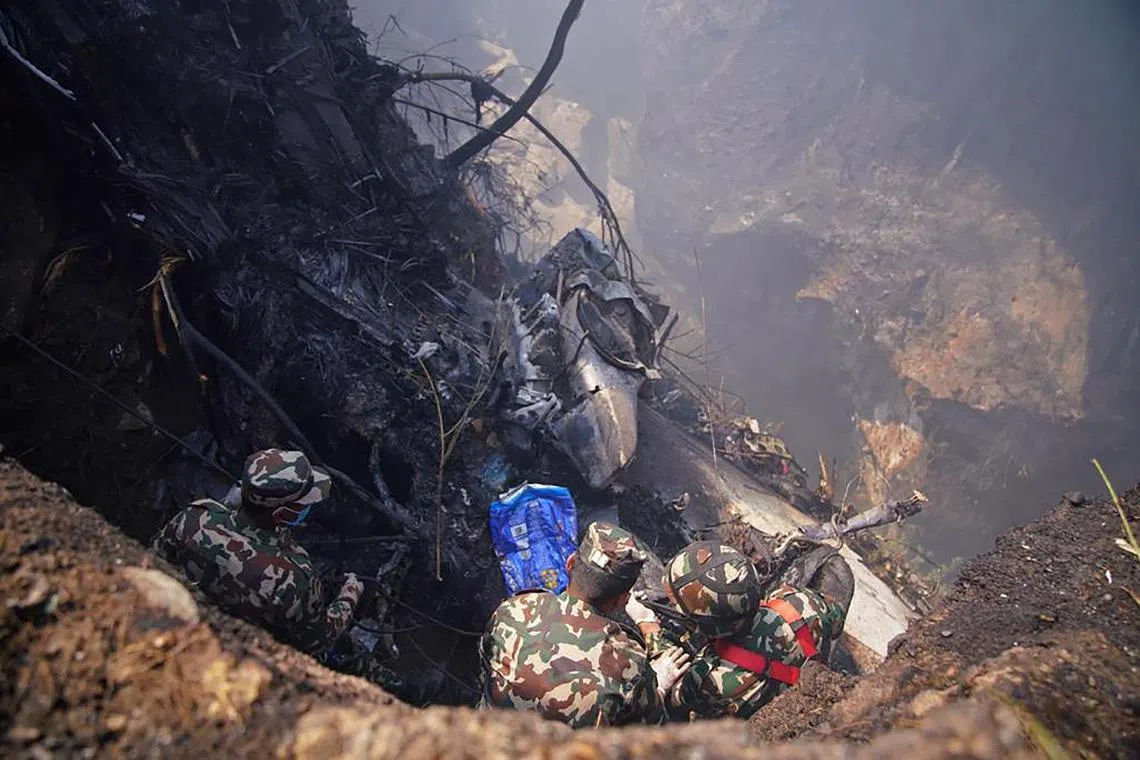 Rescuers inspect the site of a plane crash in Pokhara, Nepal, on Jan 15, 2023.  
