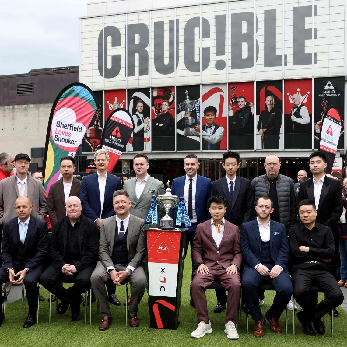 (Back row from left to R) England's Chris Wakelin, China's Xiao Guodong, Australia's Neil Robertson, England's Shaun Murphy, England's Mark Selby, China's Wu Yize, Wales' Mark Williams and China's Si Jiahui (front row from left) England's Barry Hawkins, Scotland's John Higgins, England's Kyren Wilson, China's Zhao Xintong, Northern Ireland's Mark Allen and China's Ding Junhui taking a photo with the trophy during a media day launching the start of the World Snooker Championship at Crucible Theatre in Sheffield, northern England, on April 17, 2026.