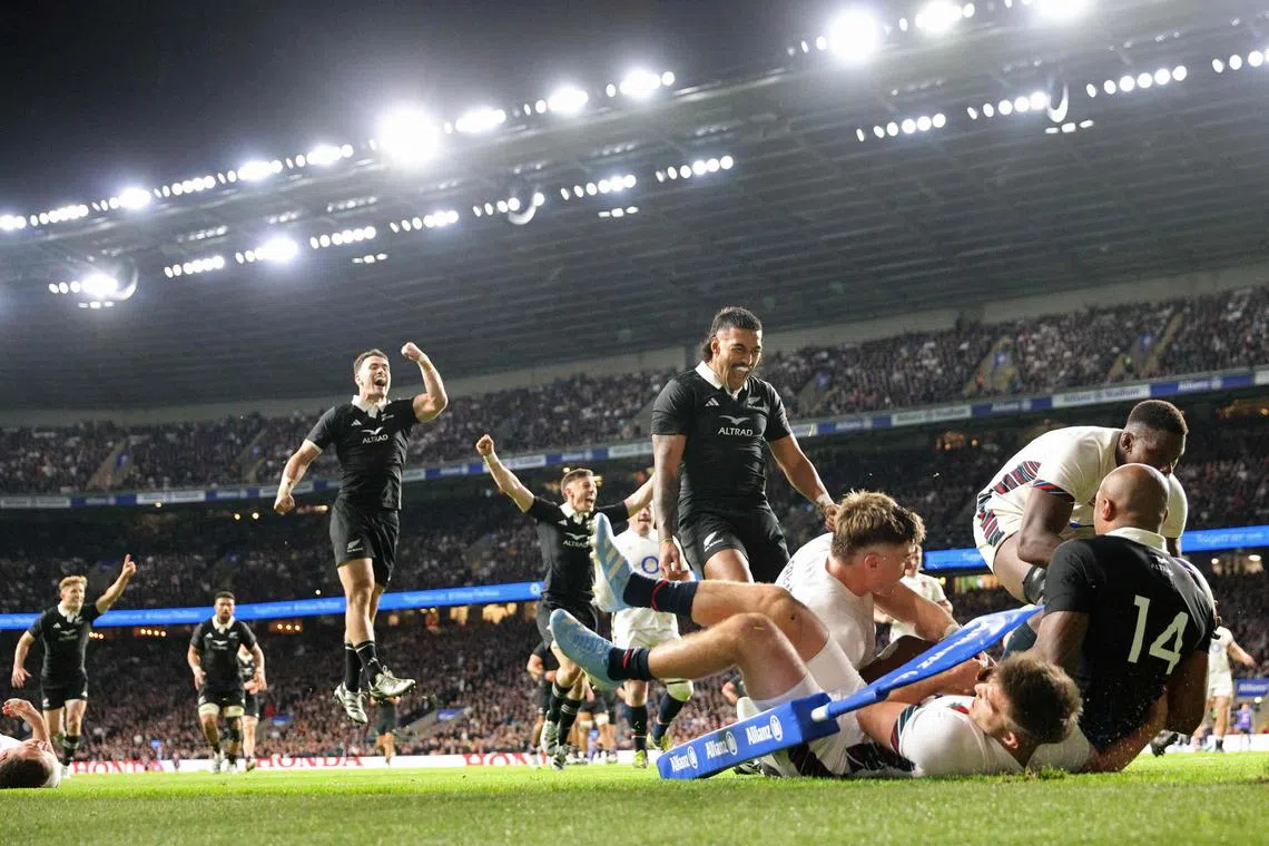 New Zealand's wing Mark Tele'a scores their third try in the corner during the international rugby union test match against England.
