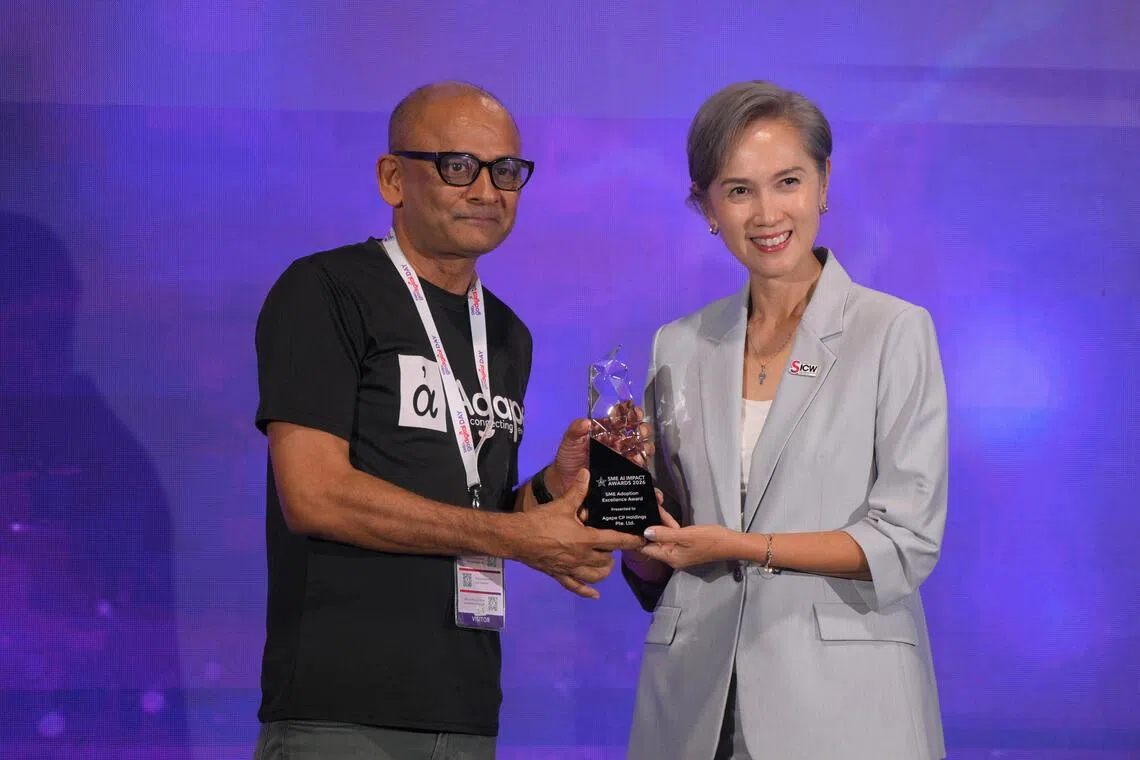 Anil David, founder of Agape Connecting People, receives his award from Minister of Digital Development and Information Josephine Teo during the SME AI Impact Awards ceremony on Oct 13.