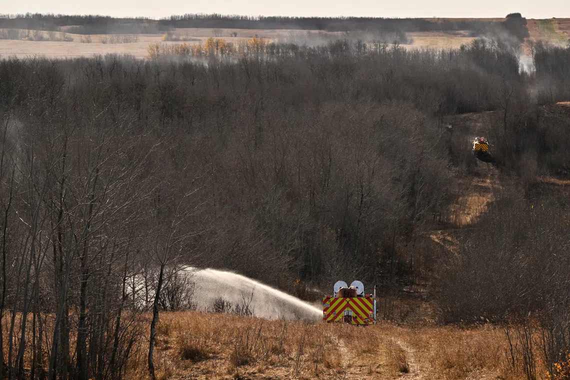 Firefighters continue to work on hot spots, the day after a serious incident that resulted in a fire caused deaths and injuries, in Wainwright, Alberta, Canada, October 18, 2026. REUTERS/Jennifer Gauthier