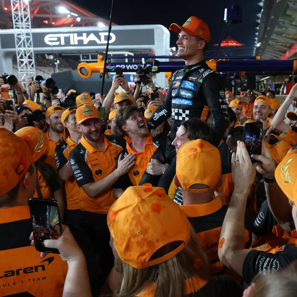 McLaren driver Lando Norris of Britain being lifted by team members after winning the 2025 Formula One drivers' world championship after the Abu Dhabi Grand Prix at the Yas Marina Circuit racetrack in the United Arab Emirates on Dec  7, 2025.