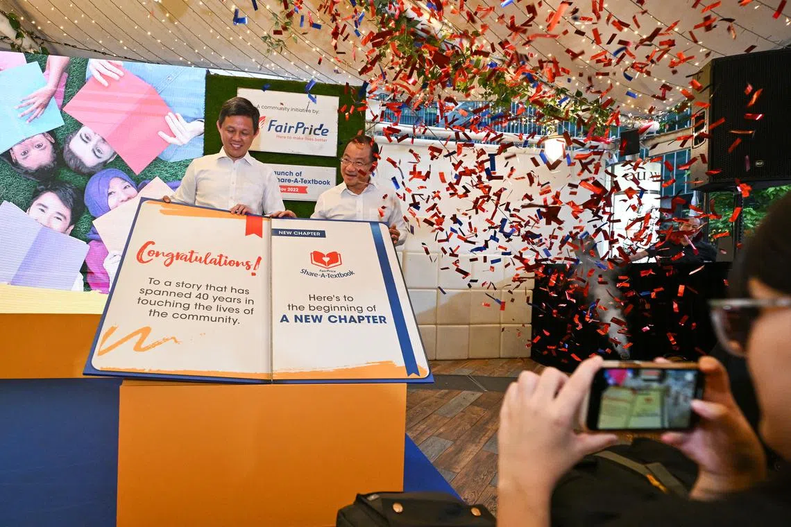 Mr Seah Kian Peng, Deputy Chairman, FairPrice, and Mr Chan Chun Sing, Minister for Education, launching the FairPrice Share-A-Textbook 2022 by flipping the page of the giant book, symbolising the start of a new chapter, at Lau Pa Sat on Tuesday.