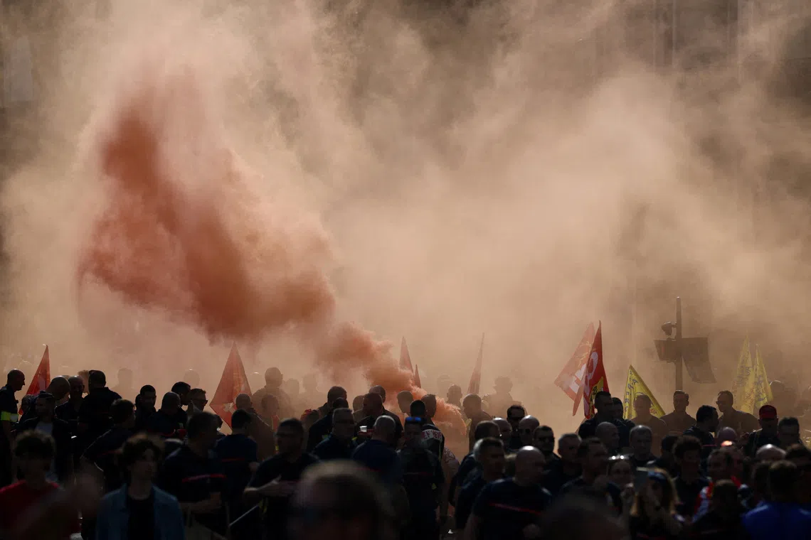 Protesters march through red smoke during a demonstration by French firefighters and public sector workers to demand better working conditions and more resources, in Paris, as part of a day of strikes and protests in France, September 29, 2026. REUTERS/Tom Nicholson TPX IMAGES OF THE DAY