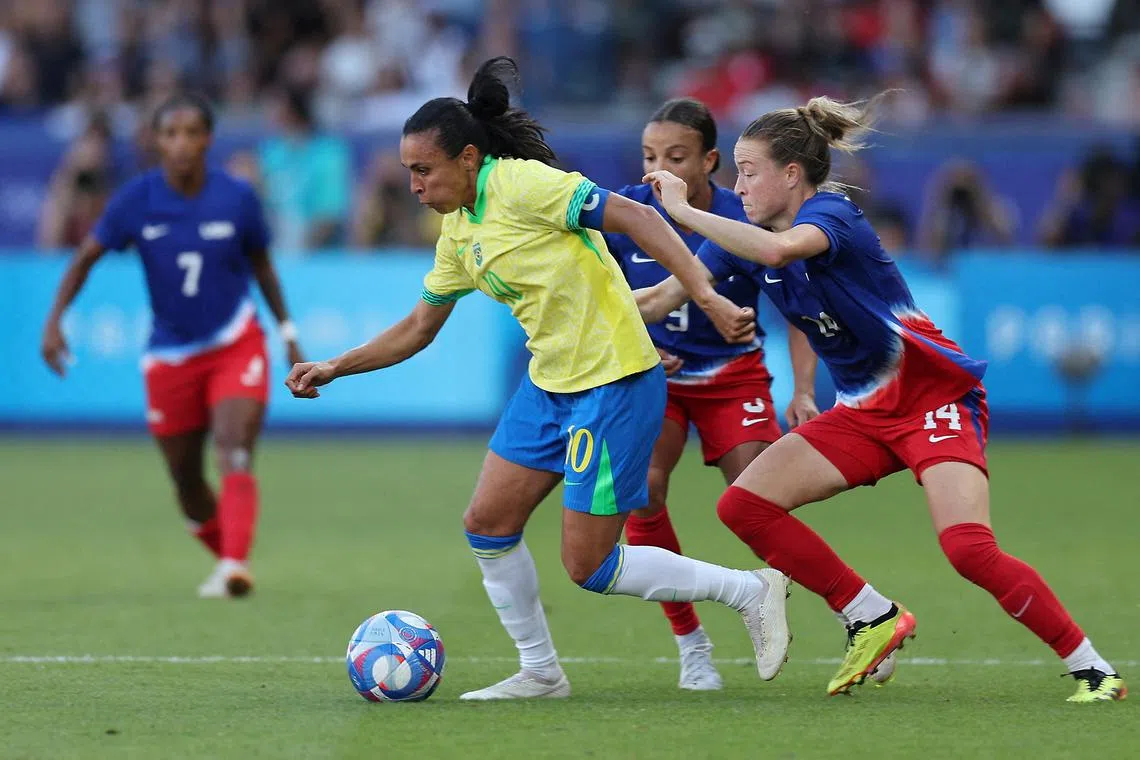 FILE PHOTO: Paris 2024 Olympics - Football - Women's Gold Medal Match - Brazil vs United States - Parc des Princes, Paris, France - August 10, 2024. Marta of Brazil in action with Emily Sonnett and Mallory Swanson of the United States. REUTERS/Lisa Leutner/File Photo