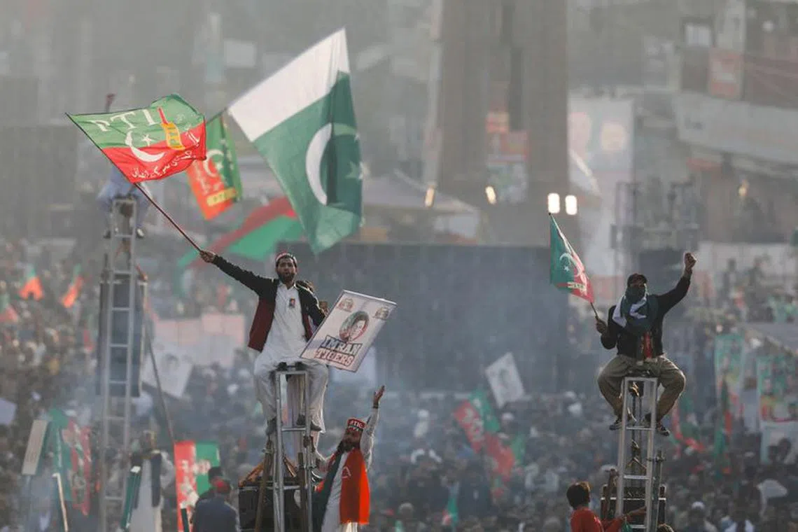Supporters of the Pakistan's former Prime Minister Imran Khan sit on scaffoldings to see their leader in Rawalpindi, Pakistan, on Nov 26, 2022. REUTERS/Akhtar Soomro/File Photo
