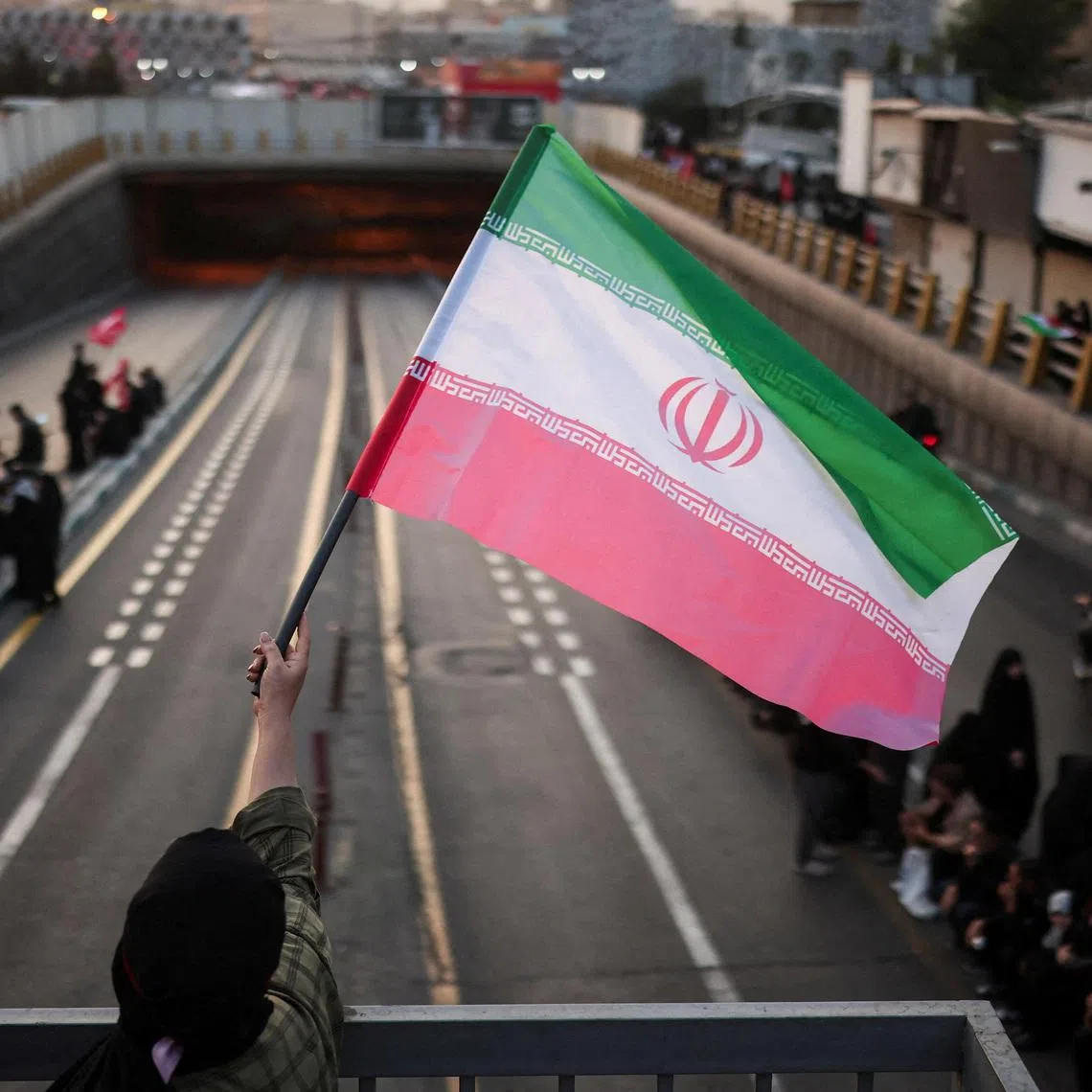 A mourner waves an Iranian flag on the day of the funeral procession for Iran's late Supreme Leader Ayatollah Ali Khamenei, who was killed on February 28 in Israeli and U.S. airstrikes, in Tehran, Iran, July 6, 2026.  REUTERS/Alkis Konstantinidis