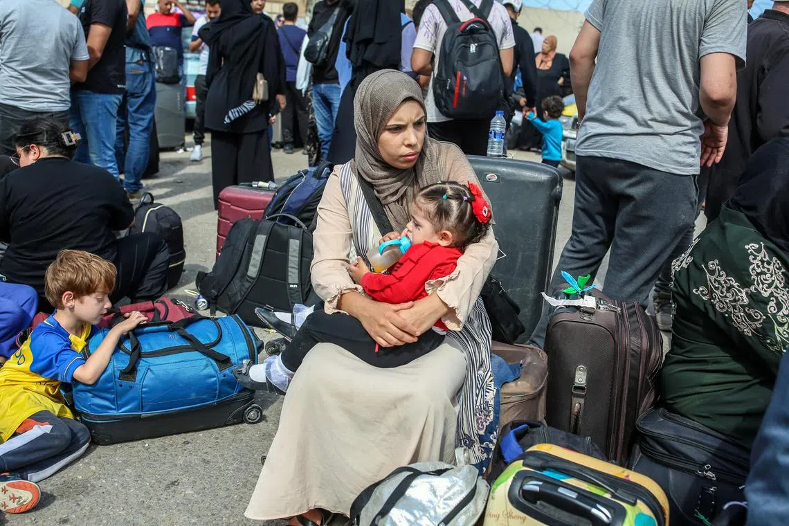 People gather on the Gaza side of the closed Rafah border crossing with Egypt on Oct 16, 2023.