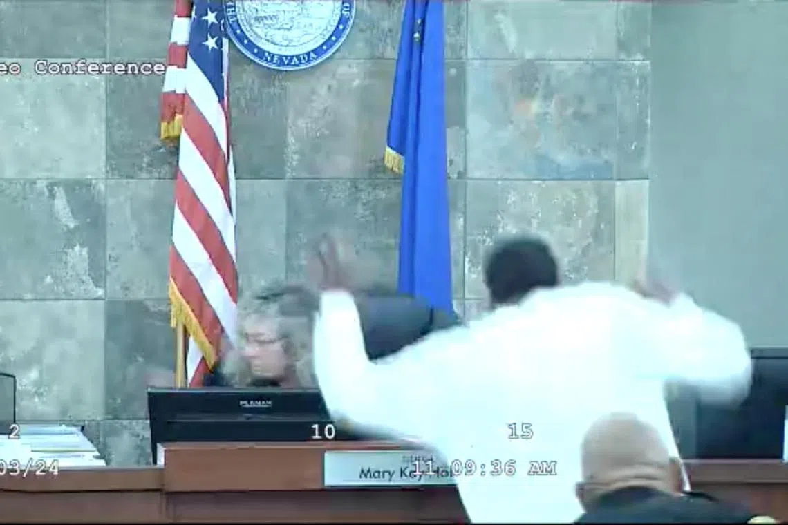 A still frame from a court video shows Redden jumping over a courtroom bench and attacking Judge Holthus.