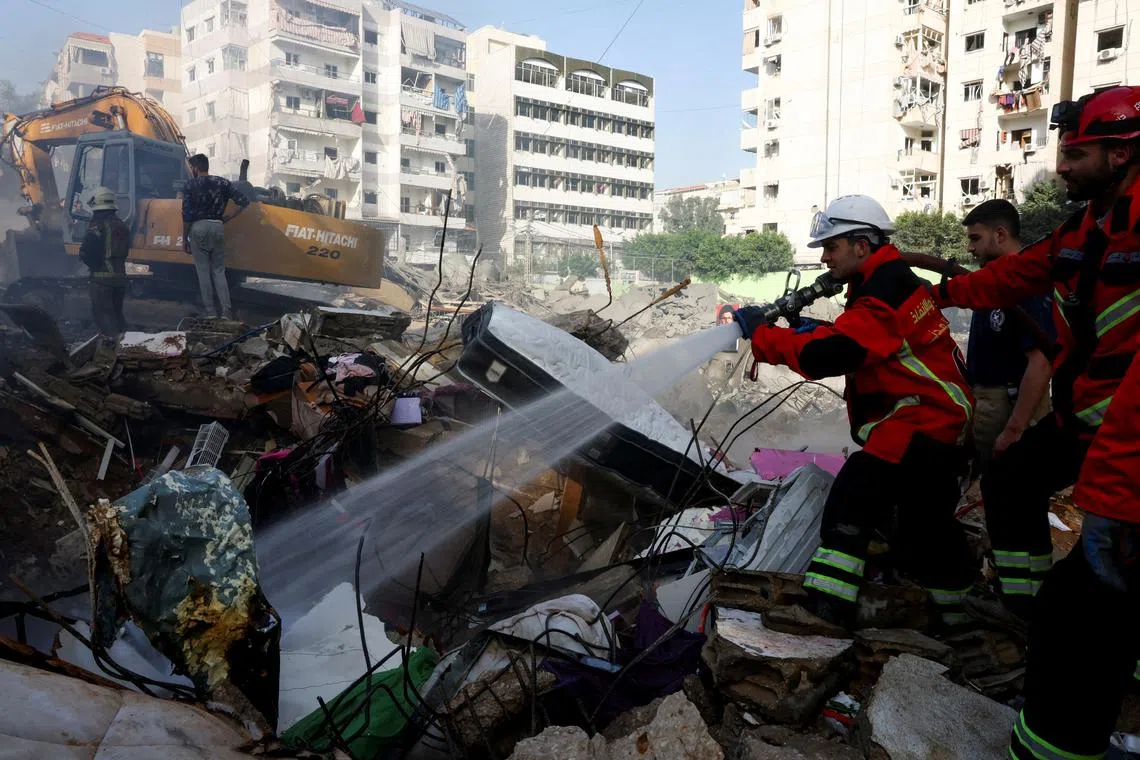 FILE PHOTO: A member of the search and rescue team from the Lebanese Civil Defense sprays water from a hose at the site of an Israeli strike, in Beirut southern suburbs, Lebanon, March 28, 2025. REUTERS/Mohamed Azakir/File Photo