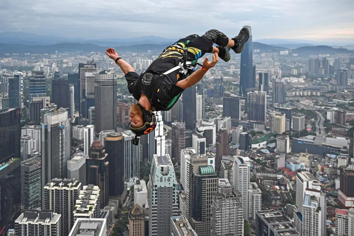 Base jumper Connor Young of Australia leaps from the 300-metre high open deck of Malaysia's landmark Kuala Lumpur Tower during the International Tower Jump in Kuala Lumpur on Feb 3, 2023. 