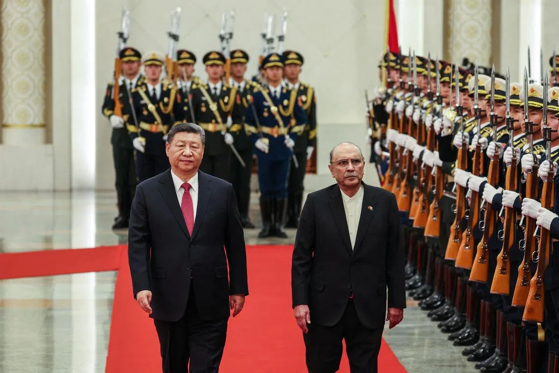 Chinese President Xi Jinping and Pakistani President Asif Ali Zardari walk past the honor guards during the welcome ceremony at the Great Hall of the People in Beijing, China, 05 February 2025. WU HAO/Pool via REUTERS