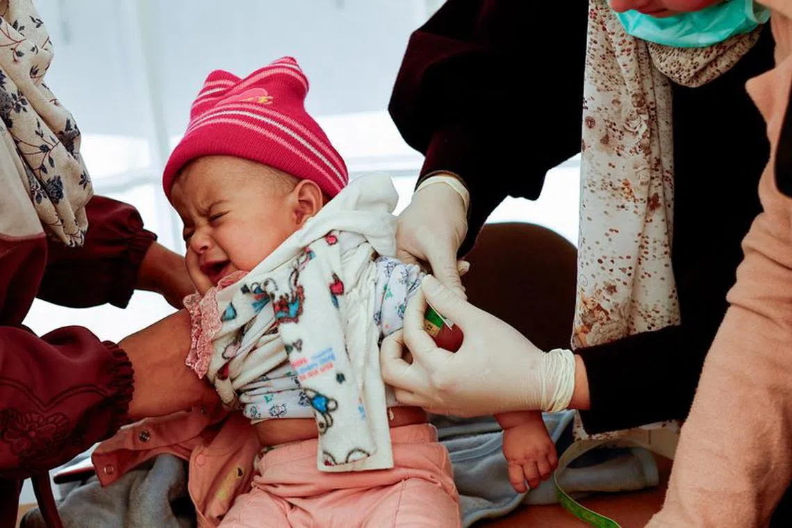A Palestinian girl has her arm measured for malnutrition at a medical tent set up by MedGlobal in cooperation with UNICEF, in Rafah, in the southern Gaza Strip, February 14, 2024. REUTERS/Ibraheem Abu Mustafa     TPX IMAGES OF THE DAY