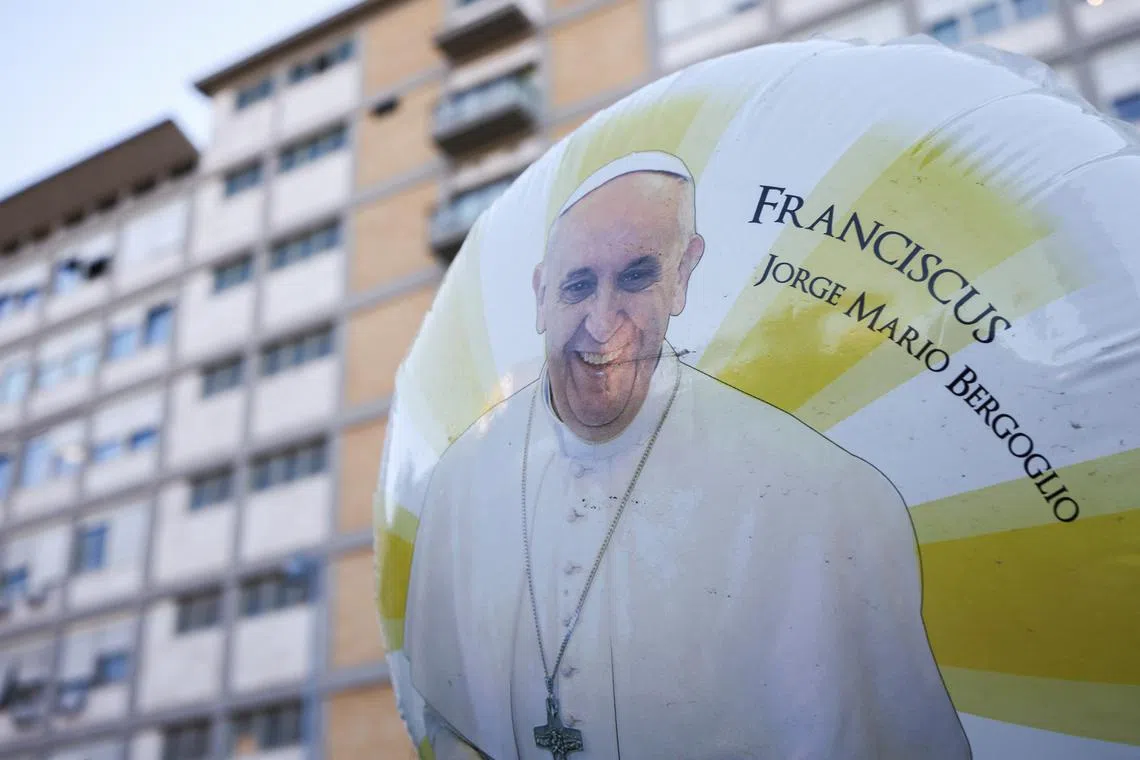A balloon with an image of Pope Francis floats outside Gemelli Hospital, as he is admitted for treatment, in Rome, Italy, March 3, 2025. REUTERS/Guglielmo Mangiapane
