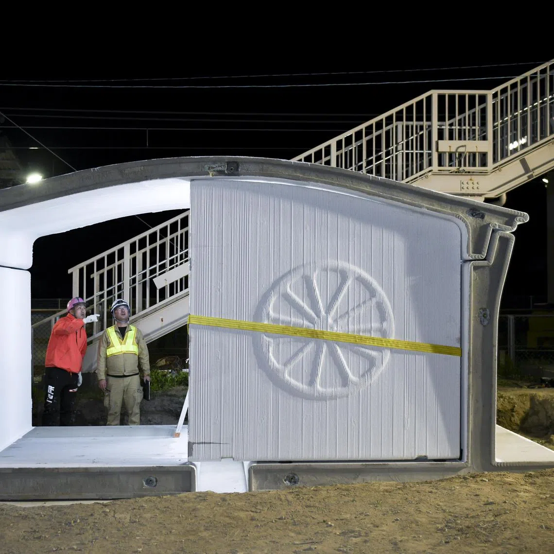 Workers assemble the new Hatsushima train station, which is made from 3D-printed components, in Arida, Japan, March 26, 2025.