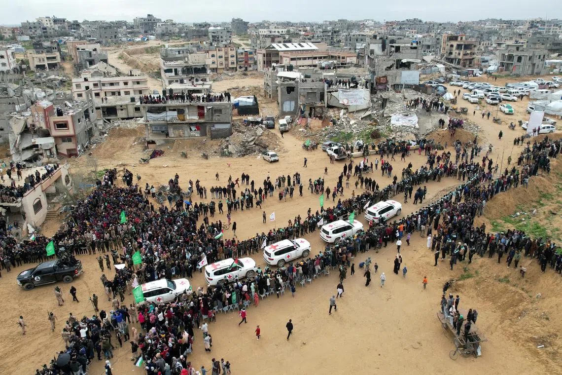 A drone view shows Palestinians and militants gathering around Red Cross vehicles on the day Hamas hands over the bodies of deceased hostages Oded Lifschitz, Shiri Bibas and her two children Kfir and Ariel Bibas, seized during the deadly October 7, 2023 attack, as part of a ceasefire and hostages-prisoners swap deal between Hamas and Israel, in Khan Younis in the southern Gaza Strip, February 20, 2025. REUTERS/Stringer