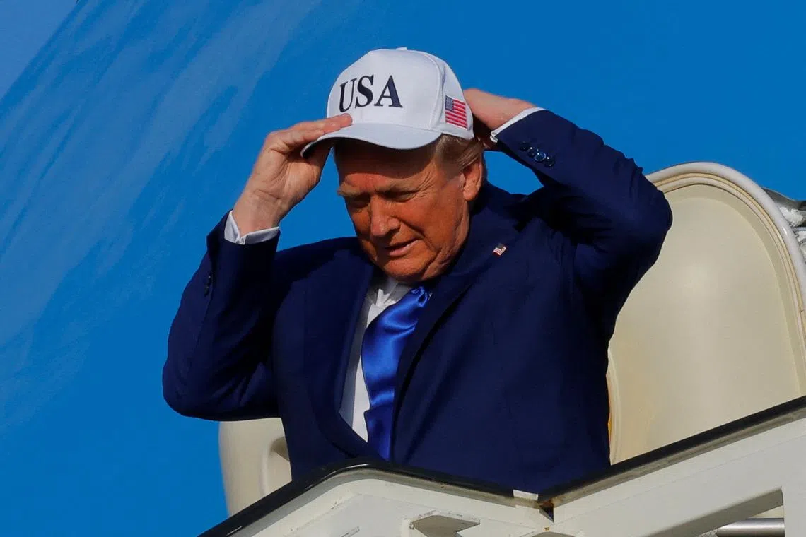 FILE PHOTO: U.S. President Donald Trump adjusts a hat as he disembarks Air Force One, as he arrives at Amsterdam Airport Schiphol in Schiphol, Netherlands, June 24, 2025. REUTERS/Brian Snyder/ File Photo