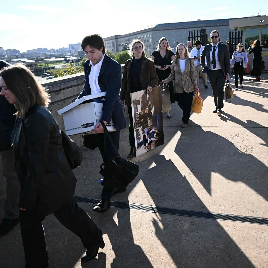 Reporters carry their belongings from the Pentagon on October 15, 2025, after news outlets declined to sign new media rules. PHOTO: AFP