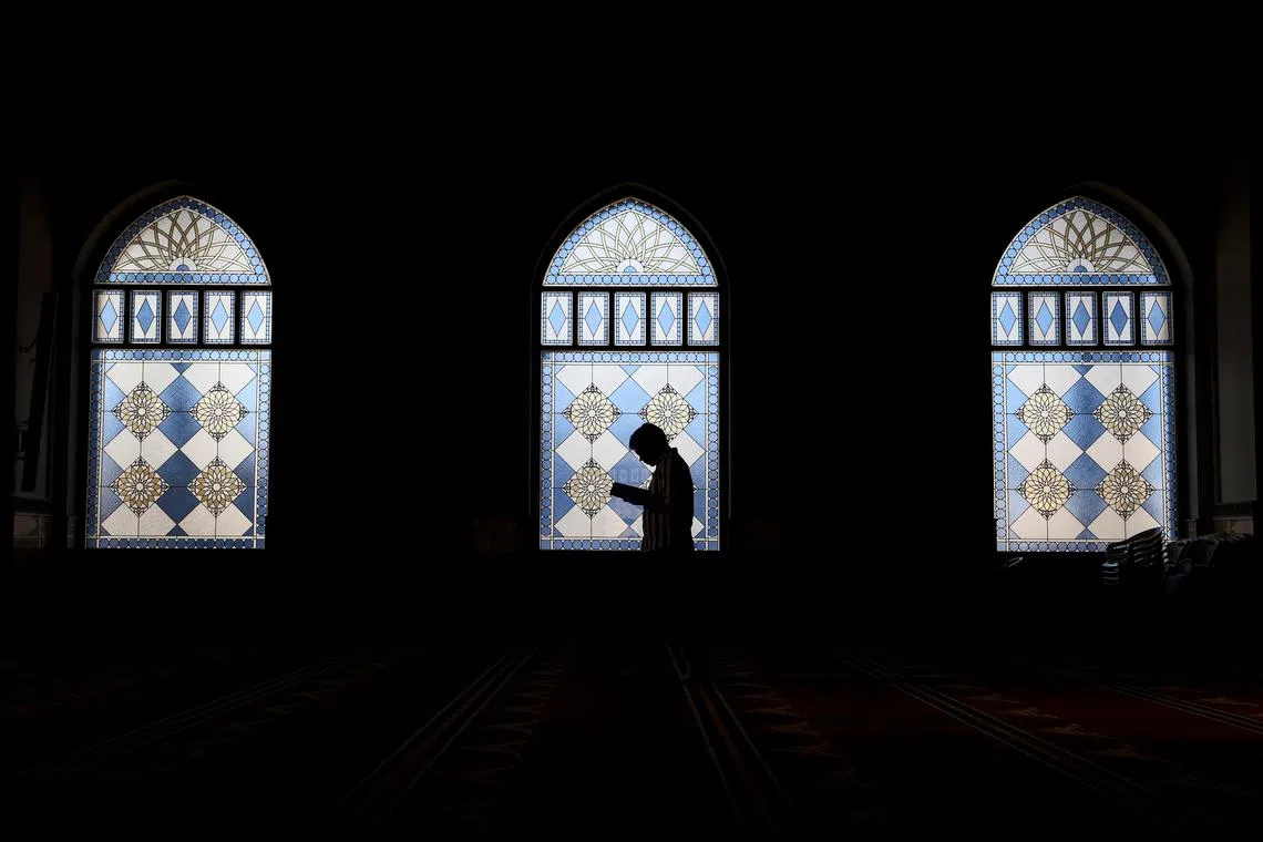 A man reading a copy of the holy Quran inside the Al Farooq Omar Bin Al Khattab Mosque in Dubai, United Arab Emirates, on March 19, 2025. 