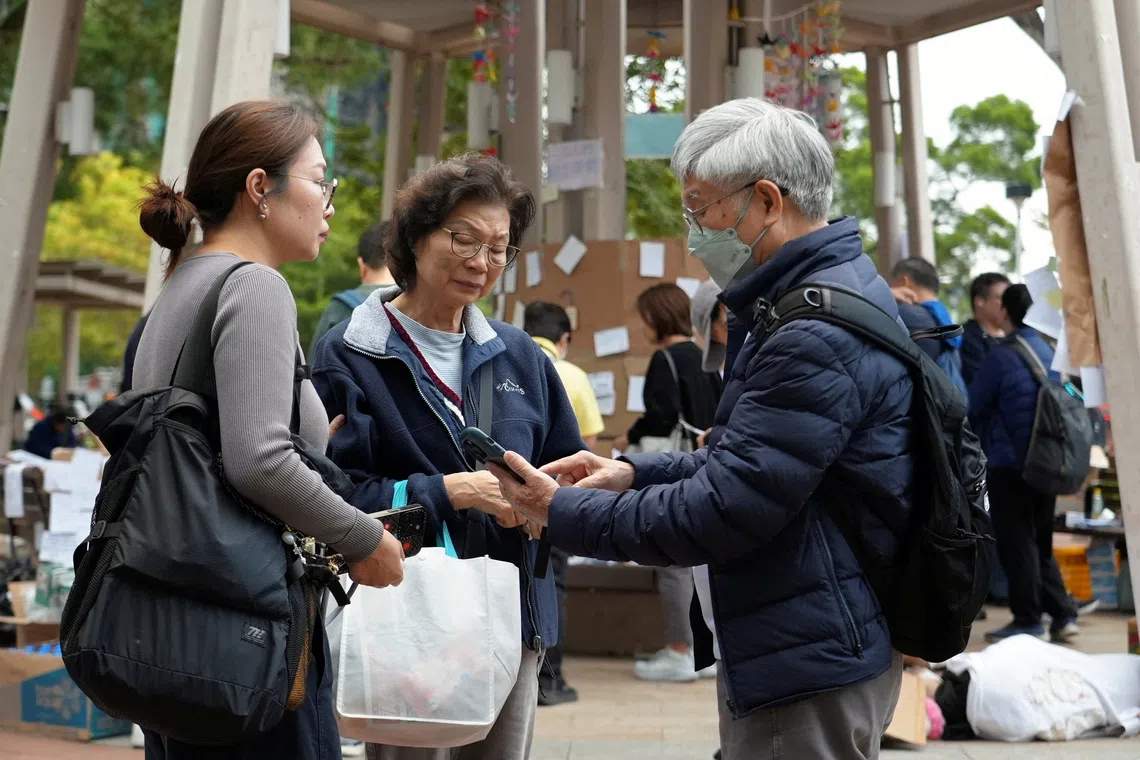 Leung, 76, and his 71-year-old wife, both residents of the Wang Fuk Court housing complex, gather with their daughter Bonnie at a nearby park where people offer tributes to victims of the deadly fire, in Tai Po, Hong Kong, China December 3, 2025. REUTERS/Joyce Zhou
