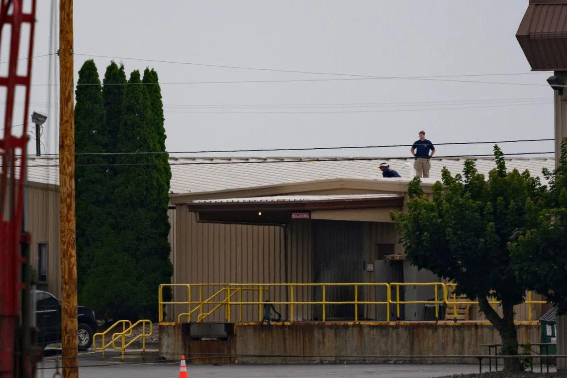 Two FBI investigators scan the roof of AGR International, the building from which alleged shooter Matthew Thomas Crooks fired at former president Donald Trump.