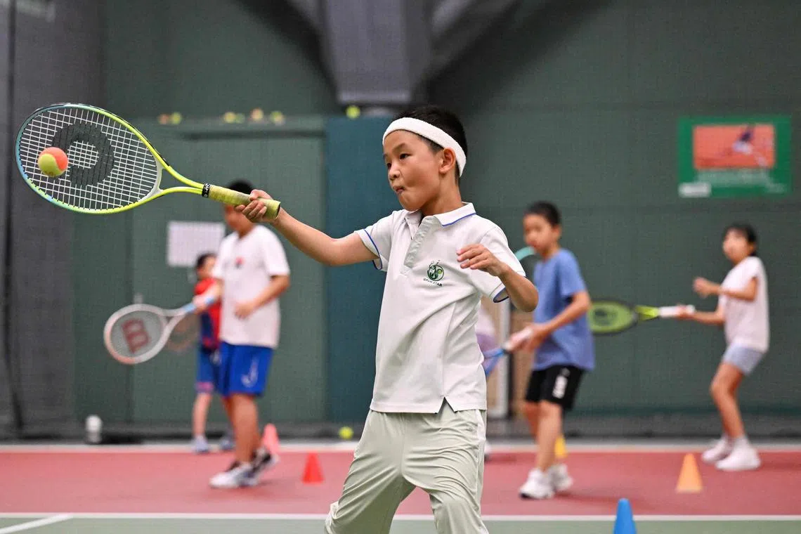 Children practise tennis at a club in Beijing on Aug 14, 2024. Zheng Qinwen's historic tennis gold at the Paris Olympics followed a decades-long surge in the sport's popularity among China's burgeoning middle class, and her victory is set to boost it even more. 