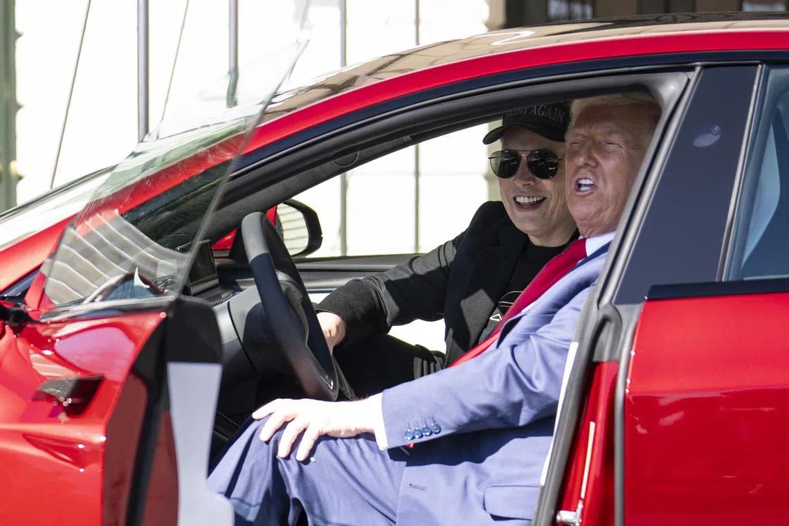United States President Donald Trump (right) and Tesla chief executive Elon Musk look at Teslas a the White House in Washington on March 11.  