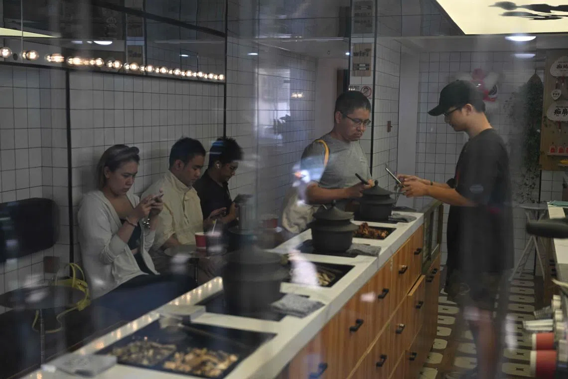 A customer (right) buys herbal tea at a cafeteria in the Xuhui district in Shanghai.