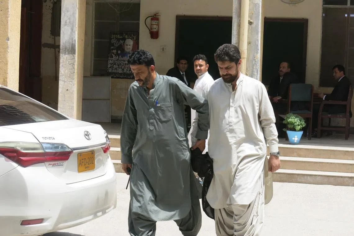 Police officers escorting tribal chief Sher Baz Satakzai (right) to a court hearing in Quetta, the provincial capital of Balochistan, on July 21.