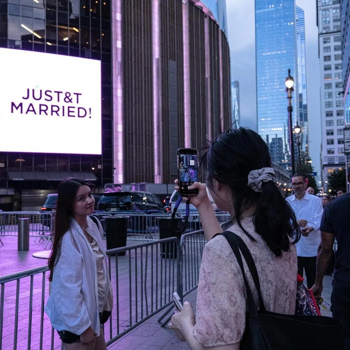 Swifties take photos outside Madison Square Garden during Taylor Swift and Travis Kelce’s wedding celebration in New York, on July 3.