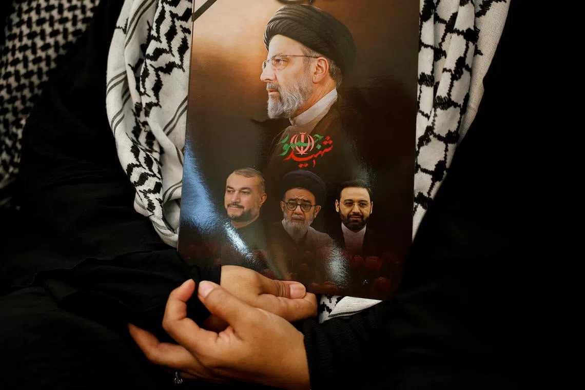 FILE PHOTO: The pictures of the late Iranian President Ebrahim Raisi along with other officials who were killed in a helicopter crash, is held during a vigil to pay tribute to them at the Iranian Ambassador's residence in Jakarta, Indonesia, May 22, 2024. REUTERS/Willy Kurniawan/File Photo