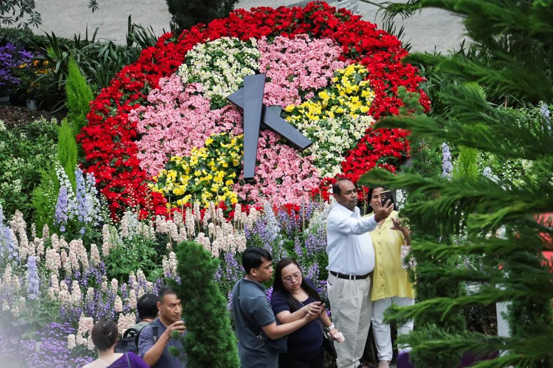 Tourists taking a photo of a replica of Geneva’s famed Flower Clock at Gardens by the Bay's Flower Dome on Sept 4.