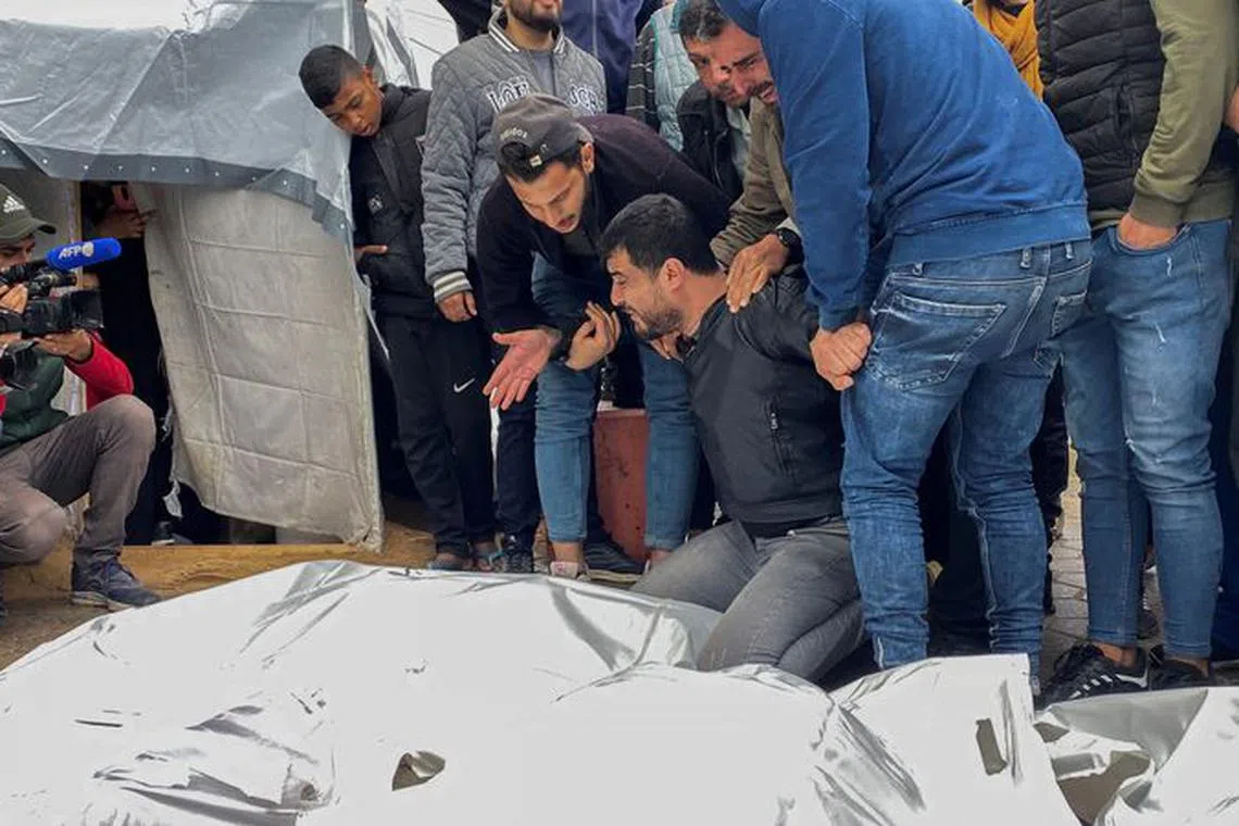 Mourners react next to the bodies of Palestinians killed in Israeli strikes, amid the ongoing conflict between Israel and Hamas, at a hospital in the central Gaza Strip, December 25, 2023. REUTERS/Doaa Ruqaa