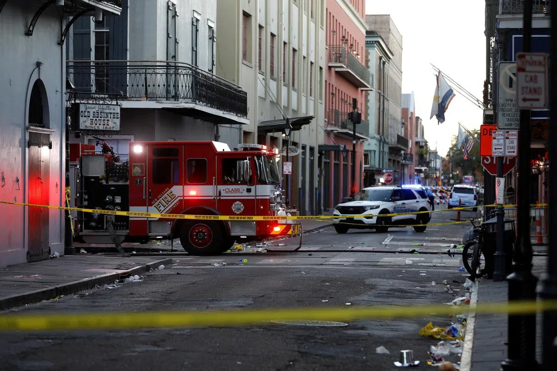 A fire truck and a police vehicle operate near the site where people were killed by a man driving a truck in an attack during New Year's celebrations, in New Orleans.