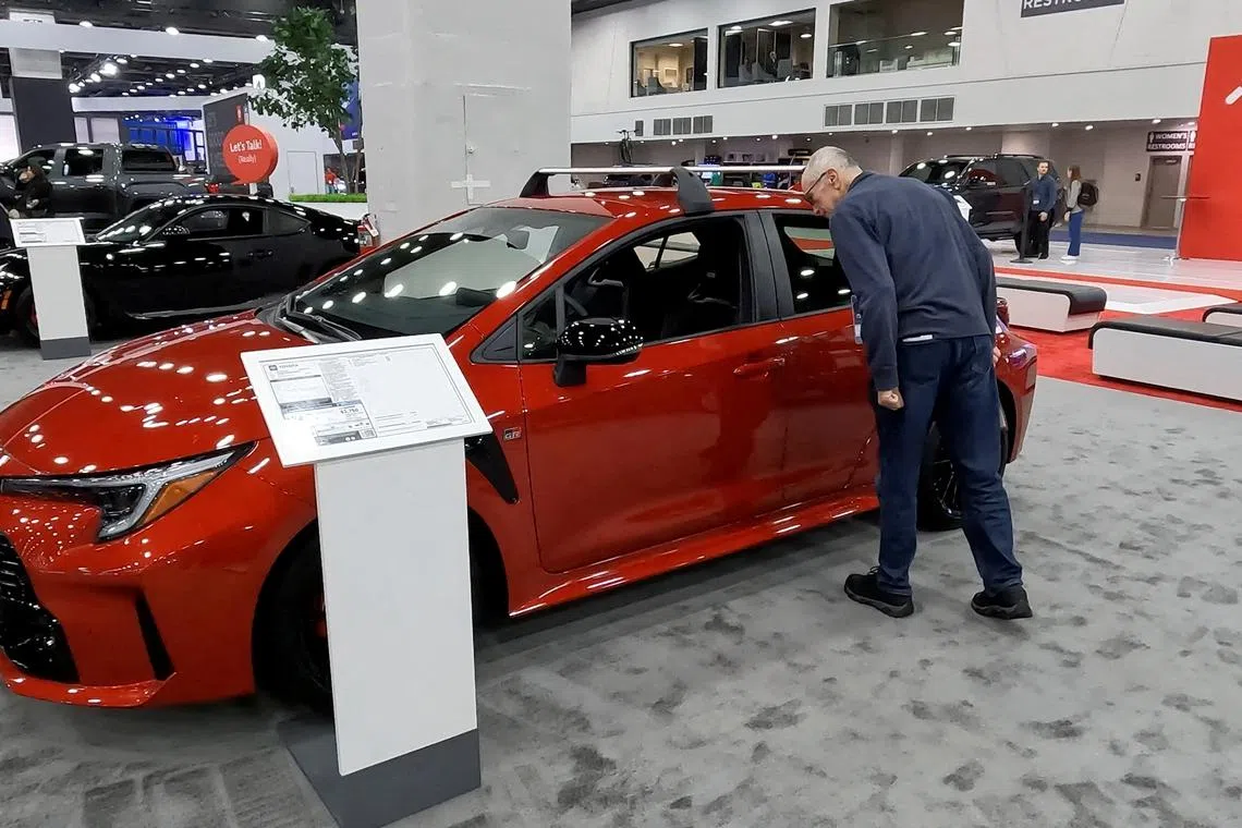 FILE PHOTO: A man gazes into the window of the 2025 Toyota Corolla Hatchback on display during media preview day at the Detroit Auto Show, in Detroit, Michigan, U.S. January 10, 2025. REUTERS/Eric Cox/File Photo