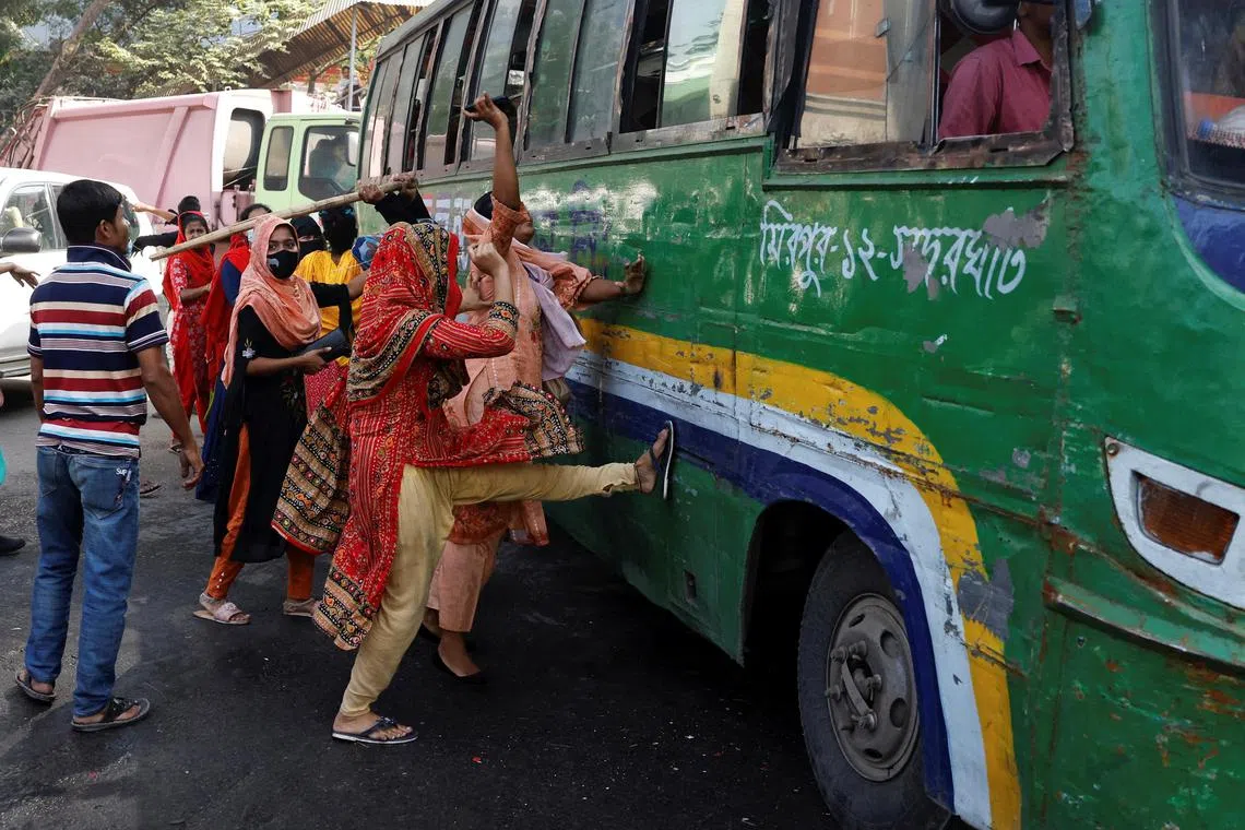 Garment industry workers try to stop vehicles, as they continue to protest on the street demanding a wage raise, at Mirpur area of Dhaka, Bangladesh, November 12, 2023. REUTERS/Mohammad Ponir Hossain     TPX IMAGES OF THE DAY     