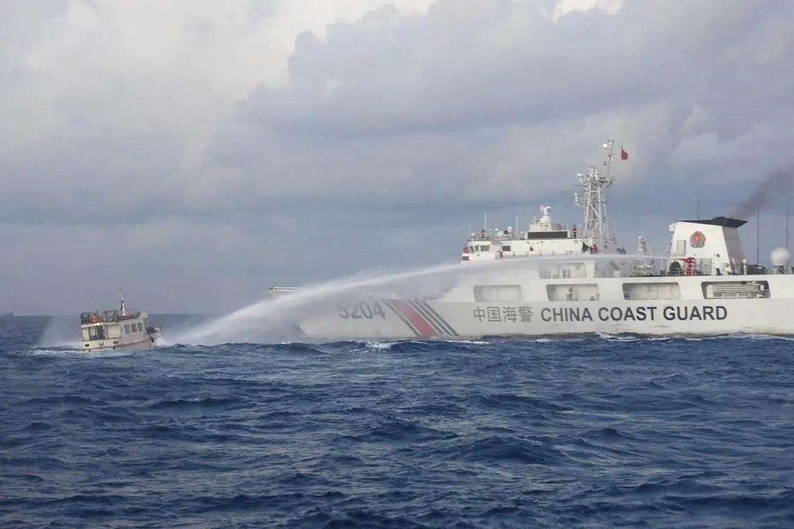 A handout photo taken in December shows a China Coast Guard vessel using water cannon against a Philippine supply boat.