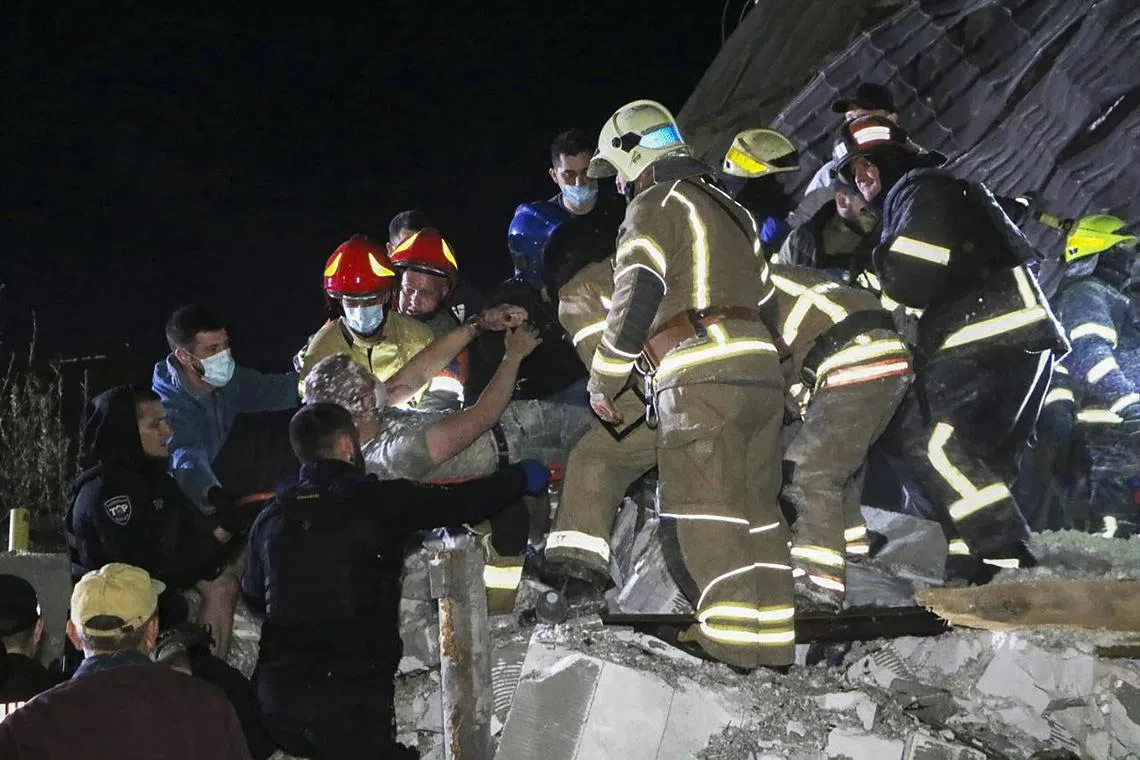 Rescuers work at the scene of a suspected Russian missile attack, in the Dnipro area of central Ukraine.