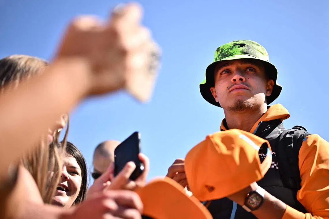 McLaren's British driver Lando Norris signing autographs before the first practice session of the Formula One British Grand Prix at Silverstone on July 7, 2023.