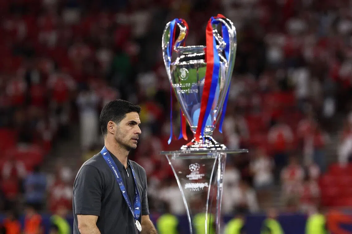 Arsenal manager Mikel Arteta walking past the Champions League trophy after losing to Paris Saint-Germain on May 30.