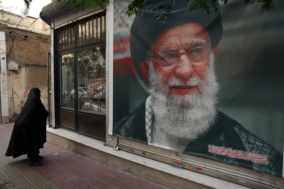 FILE PHOTO: A woman walks past a banner with a picture of the late Iran's Supreme Leader Ayatollah Ali Khamenei, on a street in Tehran, Iran June 7, 2026. Majid Asgaripour/WANA (West Asia News Agency) via REUTERS/File Photo
