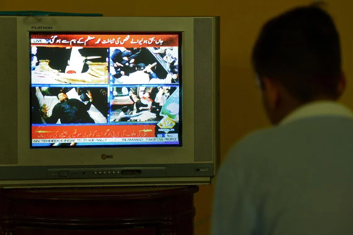 A boy watches a television channel showing the news of Pakistan's former prime minister Imran Khan, in Islamabad on November 3, 2022. - Khan was in stable condition after being shot in the leg at a political rally on November 3 in what the country's president deemed "a heinous assassination attempt". (Photo by Farooq NAEEM / AFP)