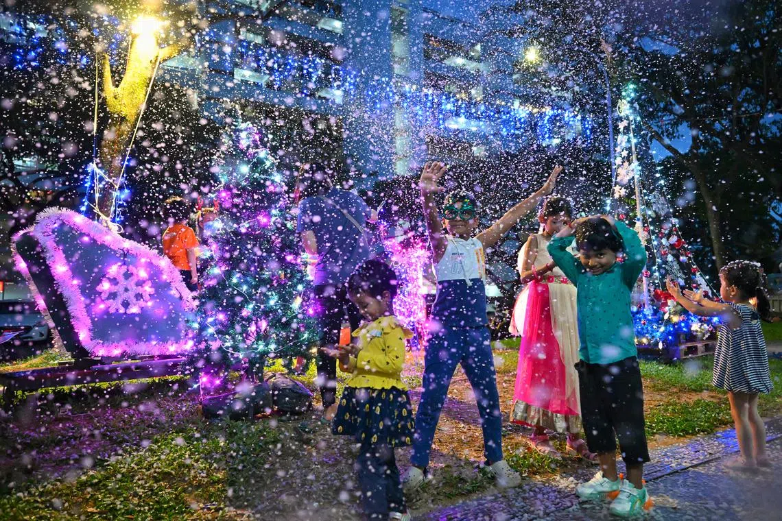Children enjoying a “white” Christmas at the foot of Block 702 Bedok Reservoir Road on Dec 23, 2023. A snow foam machine was used to simulate snow, and there was an inflatable pool for children to play in.