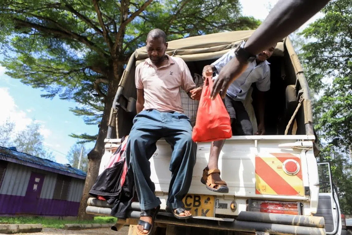 FILE PHOTO: Paul Mackenzie, 50, a Kenyan cult leader accused of ordering his followers, who were members of the Good News International Church, to starve themselves to death in Shakahola forest, alights from a police pick-up truck as he arrive at the Shanzu Law Courts, in Mombasa, Kenya May 10, 2023. REUTERS/Stringer