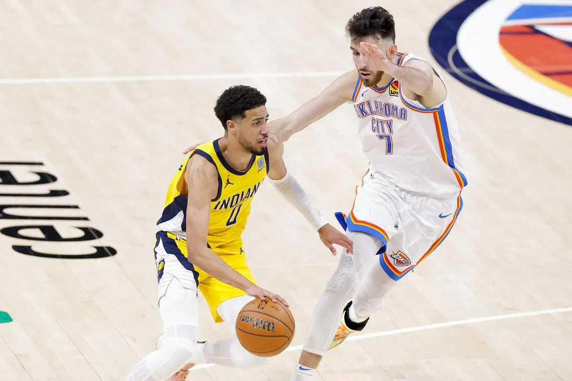 Indiana Pacers guard Tyrese Haliburton drives to the basket past Oklahoma City Thunder forward Chet Holmgren.