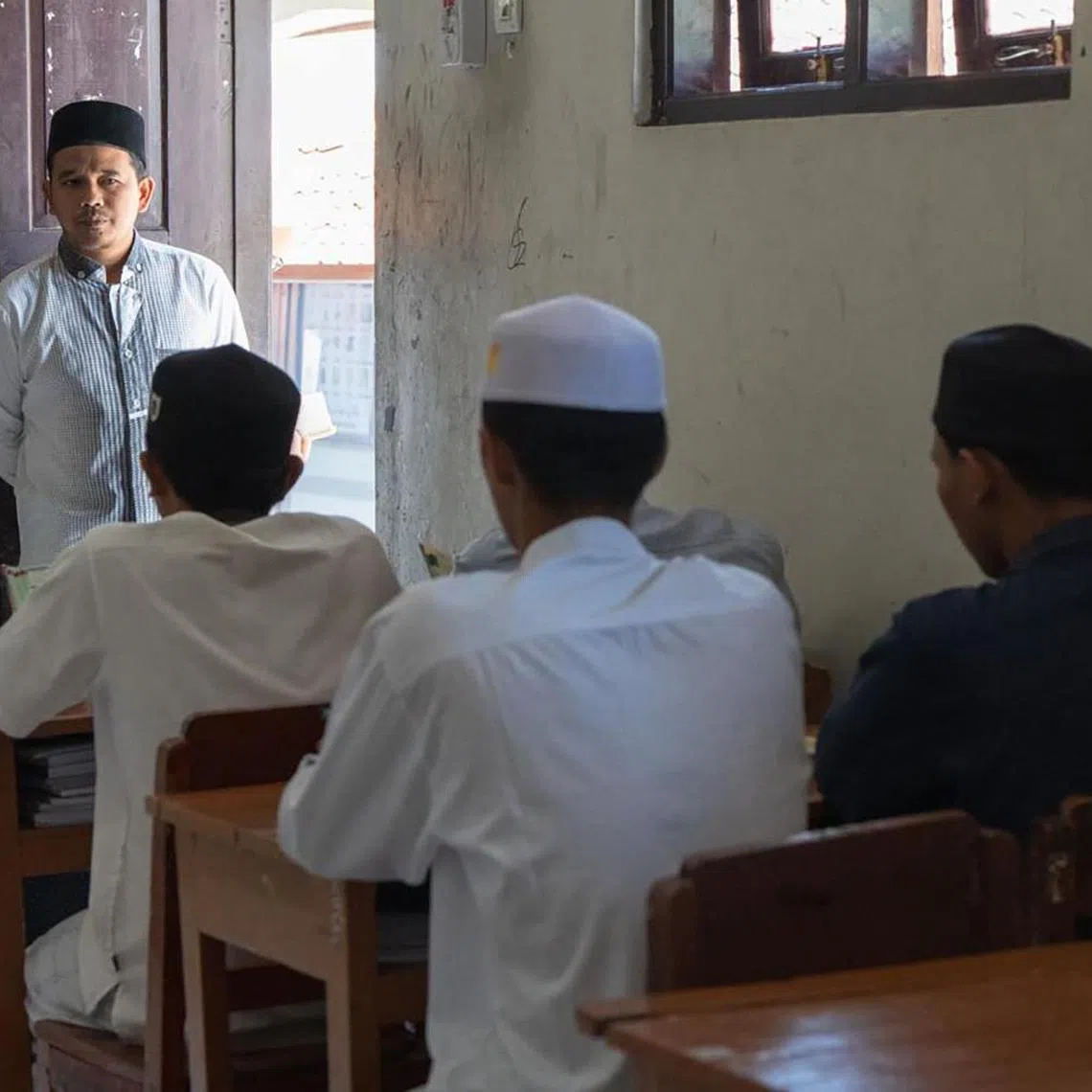 A religious teacher at Pesantren Darusy Syahadah supervises students as they recite Quranic verses on the afternoon of September 13. Besides devoting their time to the study of Islam, the students also enjoy playing sports in their free time, with mobile phones banned in the school.