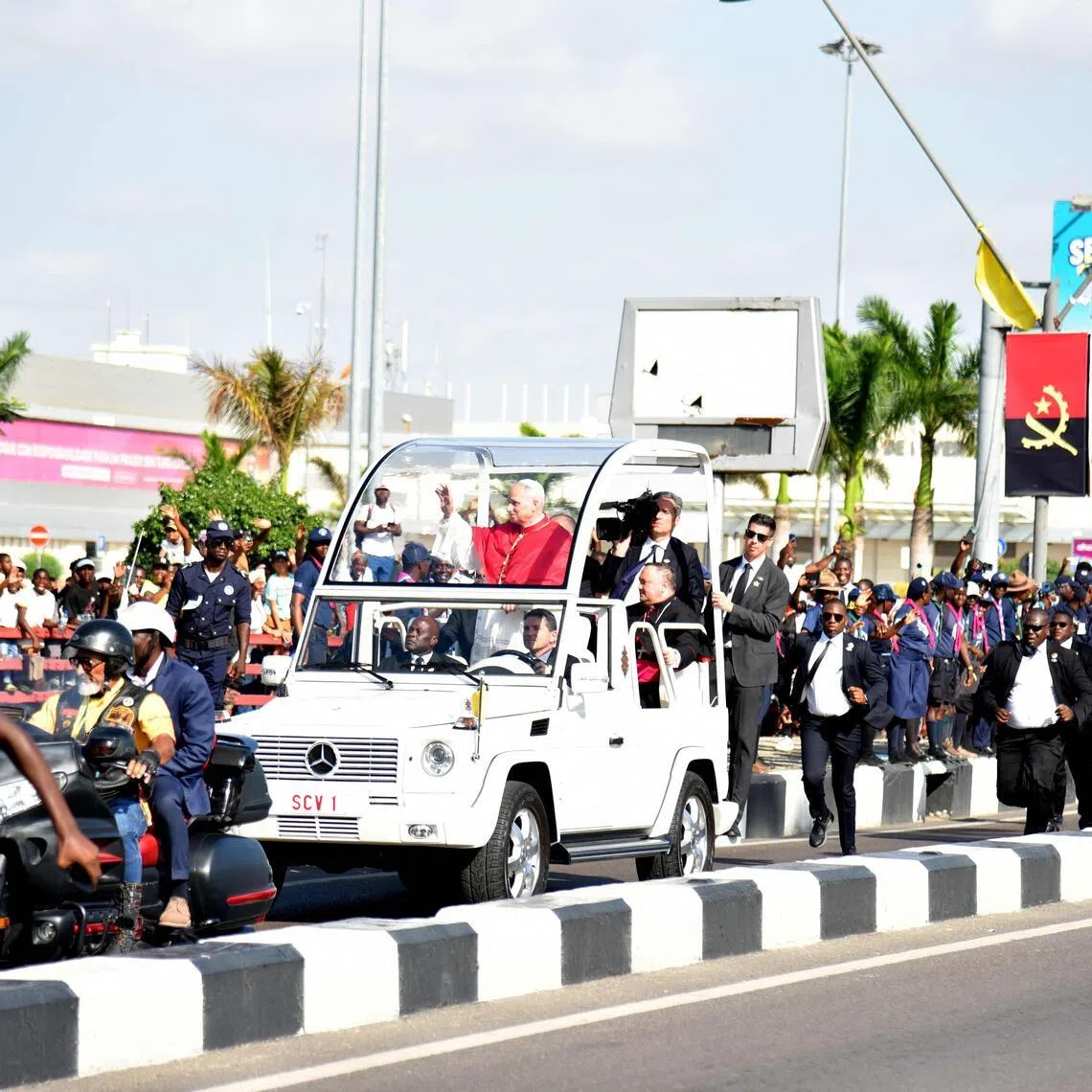 People cheering as Pope Leo XIV waves at them from the Popemobile on April 18, after his arrival in Luanda, on the sixth day of his 10-day Africa tour.