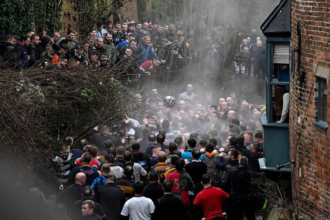 Competitors from opposing teams, the Up'ards and the Down'ards, fight for the ball during the annual Royal Shrovetide Football Match in Ashbourne, northern England, on Feb 13, 2024. The mass-participation ball game involves two teams, whose players are defined by which side of a small brook that bisects the town they were born, aiming to score a goal, which are 4.8km apart. 