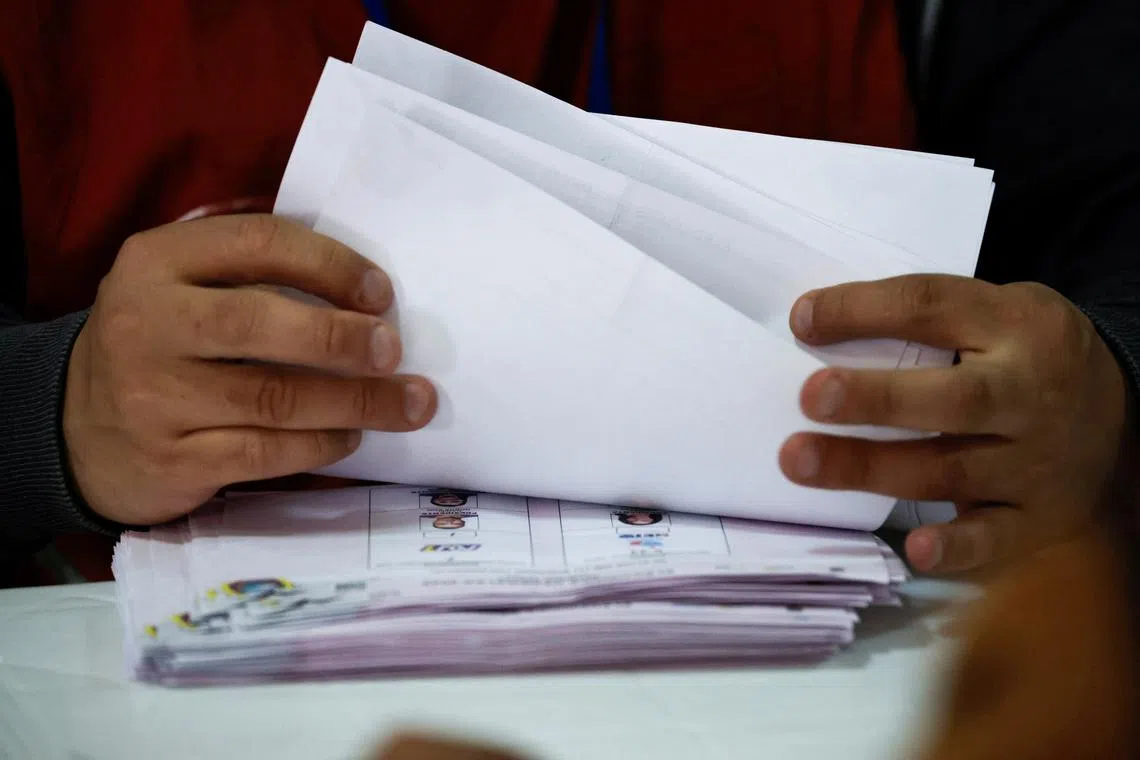 An electoral delegate reviews ballots at the Pichincha delegation of the National Electoral Council, while performing a standard audit of votes, after electoral authorities said that Ecuador’s President Daniel Noboa won the contest, in Quito, Ecuador April 14, 2025. REUTERS/Karen Toro